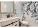 Bathroom with a white vanity, framed mirror, and a shower with a blue floral curtain at 1005 S Miller St # 102, Lakewood, CO 80226