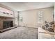 Spacious living room featuring a brick fireplace, plush carpet, and large windows at 1005 S Miller St # 102, Lakewood, CO 80226