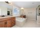 Elegant bathroom with dual vanities, soaking tub, and a separate glass enclosed shower at 11916 S Meander Way, Parker, CO 80138