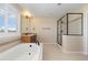 Well-lit bathroom featuring a soaking tub and glass enclosed shower with neutral color palette at 11916 S Meander Way, Parker, CO 80138