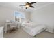 Bright bedroom with a ceiling fan, desk, and large window with plantation shutters at 11916 S Meander Way, Parker, CO 80138