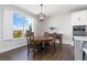 Dining area featuring natural lighting, hardwood floors, and modern light fixtures at 11916 S Meander Way, Parker, CO 80138