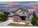 Charming two-story home featuring stone accents, a covered porch, and a well-manicured lawn at 11916 S Meander Way, Parker, CO 80138