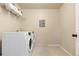 Well-lit laundry room with white front load washer and dryer and wire shelving at 11916 S Meander Way, Parker, CO 80138