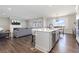 Open-concept living room and kitchen with a fireplace, hardwood floors, and abundant natural light at 11916 S Meander Way, Parker, CO 80138