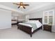 Spacious main bedroom boasts a sitting area with a fireplace, tray ceilings, and a ceiling fan at 11916 S Meander Way, Parker, CO 80138