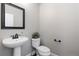Small powder room featuring pedestal sink, decorative mirror, and toilet at 11916 S Meander Way, Parker, CO 80138