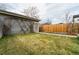 Spacious backyard featuring a well-kept lawn, garden beds, and a detached garage with climbing greenery at 4425 Quitman St, Denver, CO 80212