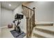 Basement workout area with exercise bike, stairs, and wood railing at 4425 Quitman St, Denver, CO 80212