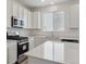 Modern kitchen featuring white cabinets, quartz counters, a gas range, and stainless appliances at 1321 Rock Cliff Ave, Erie, CO 80516