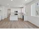 Bright, open kitchen with white cabinets, a center island, and modern appliances with vinyl flooring at 1321 Rock Cliff Ave, Erie, CO 80516