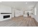 Open-concept living room with hardwood floors, fireplace, and eat-in kitchen at 1321 Rock Cliff Ave, Erie, CO 80516