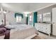 A calming bedroom featuring a dresser, mirrors, and a window with curtains at 7835 Barbara Ann Dr # F, Arvada, CO 80004