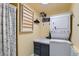 Efficient laundry room features stacked washer/dryer, utility sink, and drying rack at 7835 Barbara Ann Dr # F, Arvada, CO 80004