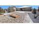 Landscaped backyard featuring a stone ground cover with a snow-covered portion and outdoor living space at 11541 Quartzite Way, Parker, CO 80138