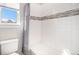 Clean bathroom with white tile, shower curtain and window for natural light at 11541 Quartzite Way, Parker, CO 80138
