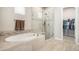 Soaking tub and glass enclosed shower with access to the walk-in closet in this bathroom at 11541 Quartzite Way, Parker, CO 80138