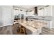 Spacious kitchen showcasing a large island with marble countertops, white cabinets, and stainless appliances at 11541 Quartzite Way, Parker, CO 80138