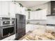 Bright kitchen featuring white cabinets, updated appliances, and a large marble island at 11541 Quartzite Way, Parker, CO 80138