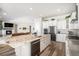 Open concept kitchen with large island, white cabinets, and stainless appliances, connecting to living room at 11541 Quartzite Way, Parker, CO 80138