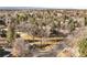 An aerial view of a home surrounded by mature trees and professional landscaping with a paved driveway at 7 Cherry Hills Farm Dr, Cherry Hills Village, CO 80113
