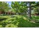 Picturesque backyard with mature trees, lush lawn, and landscaped garden beds creating a tranquil setting at 7 Cherry Hills Farm Dr, Cherry Hills Village, CO 80113
