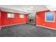 Finished basement room with brick fireplace, bright red walls, and gray carpet at 7 Cherry Hills Farm Dr, Cherry Hills Village, CO 80113