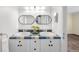 Stylish bathroom featuring double sinks with custom tile and modern oval mirrors at 7 Cherry Hills Farm Dr, Cherry Hills Village, CO 80113