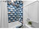 Colorful bathroom with unique blue and yellow tile, tub, shower, and vanity at 7 Cherry Hills Farm Dr, Cherry Hills Village, CO 80113