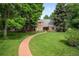 Beautiful brick home with a curved brick walkway and a spacious, manicured lawn at 7 Cherry Hills Farm Dr, Cherry Hills Village, CO 80113