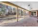 Covered outdoor patio with brick flooring, wood supports, and a view of the backyard at 7 Cherry Hills Farm Dr, Cherry Hills Village, CO 80113