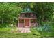 Charming playhouse featuring dormer windows, flower boxes, and a quaint porch nestled among lush greenery at 7 Cherry Hills Farm Dr, Cherry Hills Village, CO 80113