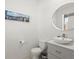 Elegant half bathroom features a round mirror, modern sink, and toilet at 6024 High Timber Cir, Castle Rock, CO 80104