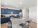 Modern kitchen with a granite countertop island, stainless steel appliances, and dark blue cabinets at 6024 High Timber Cir, Castle Rock, CO 80104