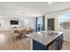 Open-concept living room, dining area, and kitchen with granite countertops and blue cabinets and new hardwood floors at 6024 High Timber Cir, Castle Rock, CO 80104