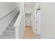 Bright hallway featuring light wood floors, white walls, and a staircase with gray carpet at 2849 E 103Rd Dr, Thornton, CO 80229