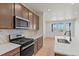 Kitchen features stainless appliances, warm cabinetry, stone backsplash, and light counters at 2849 E 103Rd Dr, Thornton, CO 80229