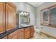 Bathroom featuring wood cabinets, black granite countertops, and a glass-enclosed shower at 1252 Rosewind Cir, Castle Rock, CO 80104