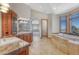 Bathroom with a soaking tub, walk-in shower, double vanity, and windows offering scenic views at 1252 Rosewind Cir, Castle Rock, CO 80104