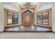 Grand foyer with soaring ceilings, a chandelier, and double wooden doors with stone accents at 1252 Rosewind Cir, Castle Rock, CO 80104