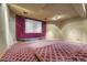 Large home theater with a big screen, red curtains, and comfortable carpeting for an immersive viewing experience at 1252 Rosewind Cir, Castle Rock, CO 80104
