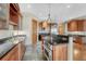 Gourmet kitchen with wood cabinets, granite countertops, tile floors, and stainless steel appliances at 1252 Rosewind Cir, Castle Rock, CO 80104
