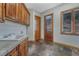 Functional laundry room with ample cabinet space, a utility sink, tile floors, and natural wood trim at 1252 Rosewind Cir, Castle Rock, CO 80104