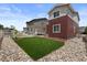 A clean backyard with lush green lawn, stone accents and patio area offering a serene outdoor space at 5297 Blue Lunar Ln, Castle Rock, CO 80104