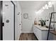 Well-lit bathroom with double vanity, granite countertops, and a modern glass-enclosed shower at 5297 Blue Lunar Ln, Castle Rock, CO 80104