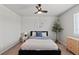This well-lit bedroom showcases a ceiling fan, neutral walls, and a stylish bed with a blue accent at 5297 Blue Lunar Ln, Castle Rock, CO 80104