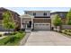 Attractive two-story home featuring a stone facade, a two-car garage, and lush front yard landscaping at 5297 Blue Lunar Ln, Castle Rock, CO 80104