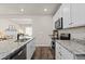 Modern kitchen featuring stainless steel appliances, granite countertops, an island, and white cabinets at 5297 Blue Lunar Ln, Castle Rock, CO 80104