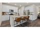 Well-lit kitchen with white cabinets, stainless steel appliances, granite countertops and an island with seating at 5297 Blue Lunar Ln, Castle Rock, CO 80104