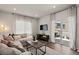 Bright living room with L-shaped couch, large windows, hardwood floors, and sliding doors to the patio at 5297 Blue Lunar Ln, Castle Rock, CO 80104